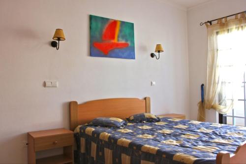 a bedroom with a bed and a painting on the wall at Akivillas Albufeira Relax in Albufeira