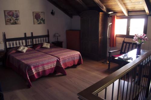 a bedroom with a bed and a table and a window at Vivelorural Casa Tunte 2, BBQ y terraza in San Bartolomé de Tirajana
