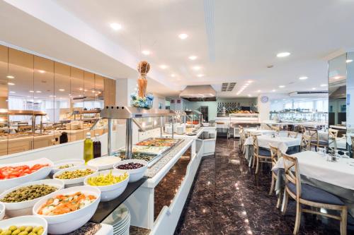 a buffet line with plates of food in a restaurant at Hotel Don Miguel Playa in Playa de Palma