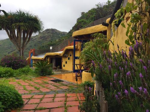 a house with a brick walkway in a garden at Vivelorural casa La Cuevita, Santa Brígida in Santa Brígida
