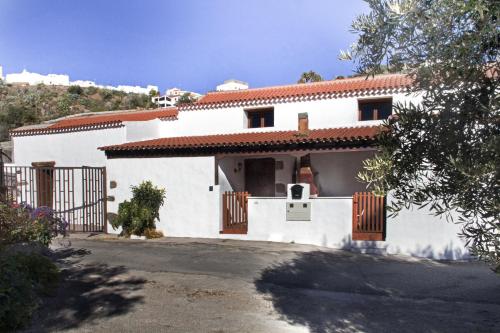 a white house with a gate and a driveway at Casa rural en Hoya de Tunte 2 in San Bartolomé