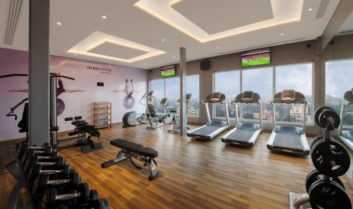 a gym with treadmills and exercise equipment in a building at Novotel Guwahati GS Road in Guwahati