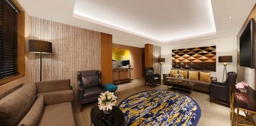 a living room with a couch and a table in a room at Novotel Guwahati GS Road in Guwahati