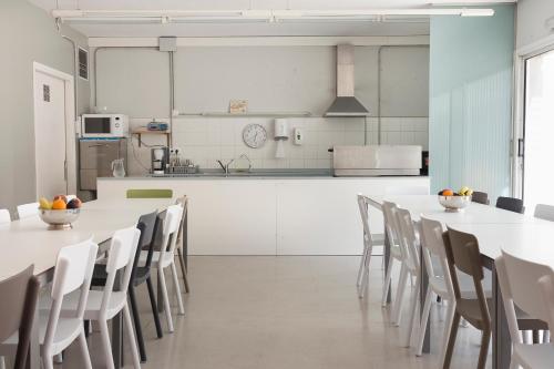 a kitchen and dining room with white tables and chairs at Residència Universitària Sant Joan in Reus