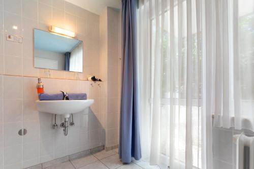 a bathroom with a sink and a mirror and a window at Hotel Helgolandia in Helgoland