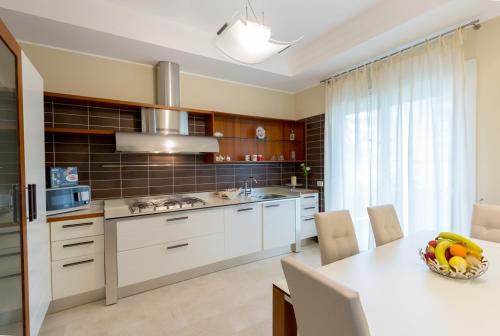 a kitchen with a table with a bowl of fruit on it at Aparthotel England in Riccione