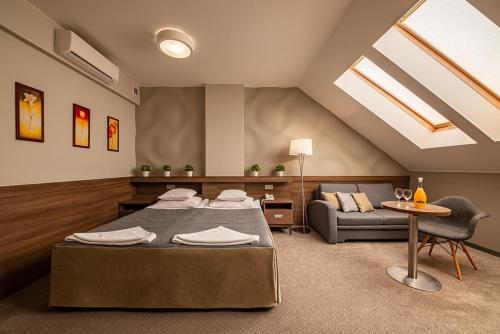 salon z 2 łóżkami i kanapą w obiekcie Hotel Konstancja w mieście Konstantynów Łódzki