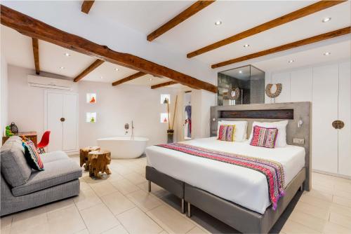 a bedroom with a bed and a bath tub and a chair at Ibizazen in Santa Eularia des Riu