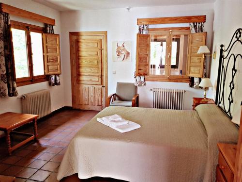 アロヨ・フリオにあるApartamentos Cazorla Valleのベッドルーム1室(ベッド1台、椅子、窓付)