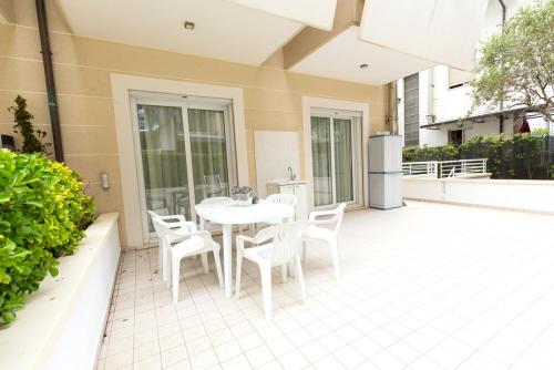 a white table and chairs on a patio at Aparthotel England in Riccione