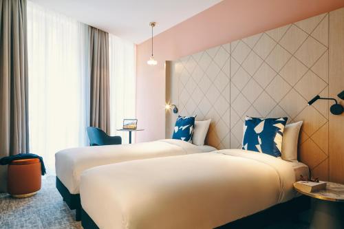 two beds in a hotel room with blue accents at Mercure Marseille Canebière Vieux-Port in Marseille