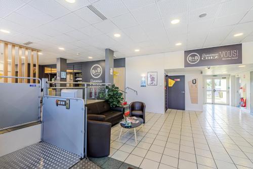 a lobby with a couch and a waiting room at B&B HOTEL Besançon Chateaufarine in Besançon