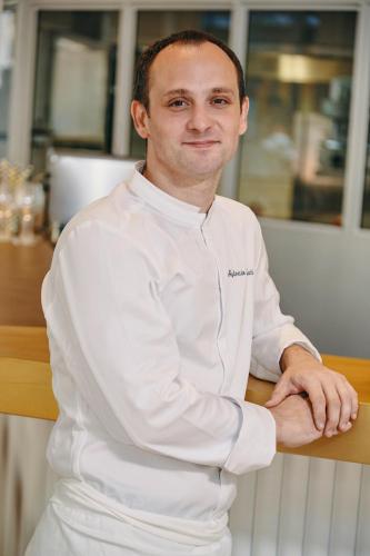 a man in a chefs outfit standing in a kitchen at Mercure Marseille Canebière Vieux-Port in Marseille