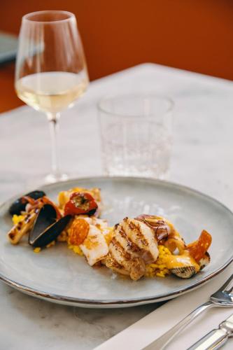 a plate of food on a table with a glass of wine at Mercure Marseille Canebière Vieux-Port in Marseille
