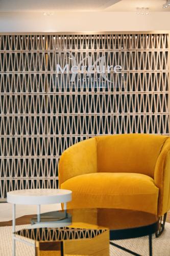a living room with a yellow couch and a geometric wall at Mercure Marseille Canebière Vieux-Port in Marseille