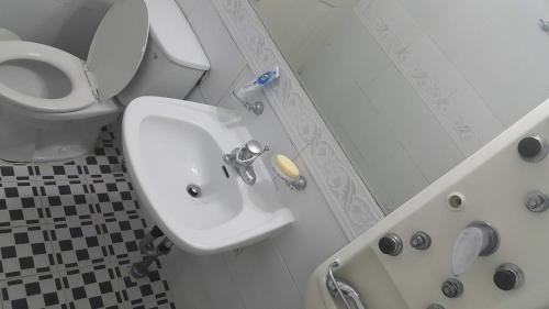 Baño blanco con aseo y lavamanos en Gyeongju Guesthouse, en Gyeongju