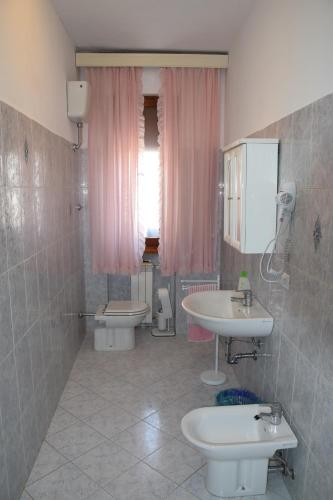 baño con 2 lavabos, aseo y cortinas rosas en camera trebbio, en San Piero a Sieve