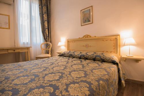ヴェネツィアにあるアルベルゴ カーサ ペロンのベッドルーム1室(青い掛け布団付きのベッド1台付)