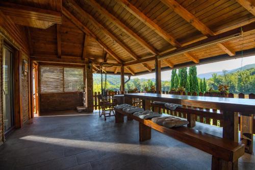 a large room with benches and a large window at Holiday Home Drinsko svitanje in Gornja Trešnjica