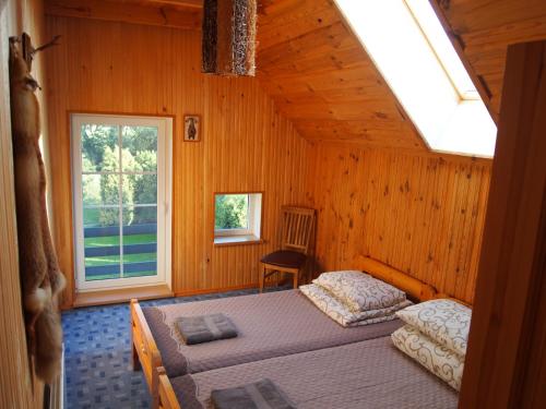 a bedroom with two beds and a window at Sodyba Senoji Rusnė in Rusnė