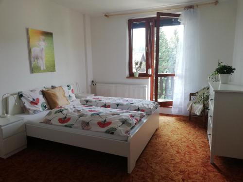 1 dormitorio con cama y ventana en Deštné 371 - Buďte na horách jako doma en Deštné v Orlických horách