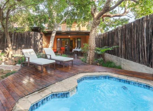 a backyard with a swimming pool and a wooden deck at Riverstone Lodge in Muldersdrift