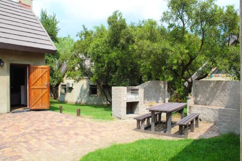 a picnic table and a bench in a yard at Umuzi Lodge in Secunda