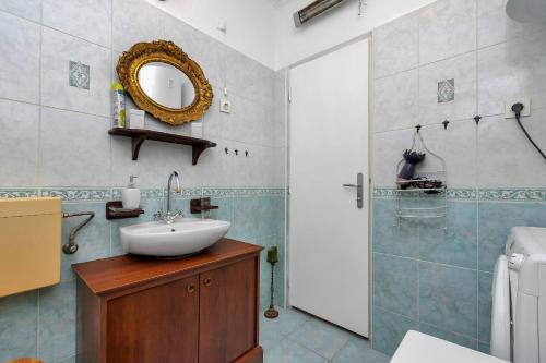 a bathroom with a sink and a mirror at Apartman Lovreta - Ivano in Makarska