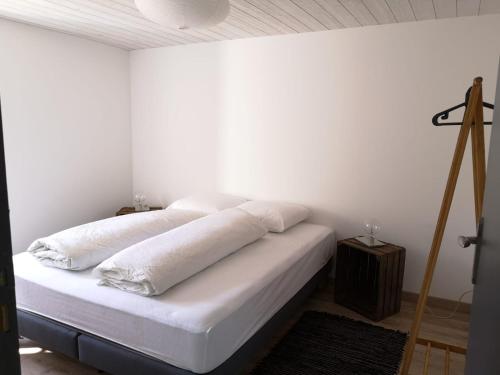 a white bedroom with a bed with white sheets at La Ferme des Potets in Fresse
