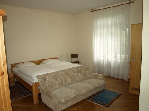 a bedroom with a bed and a couch and a window at Hotel Villa Arnold in Bad Kissingen