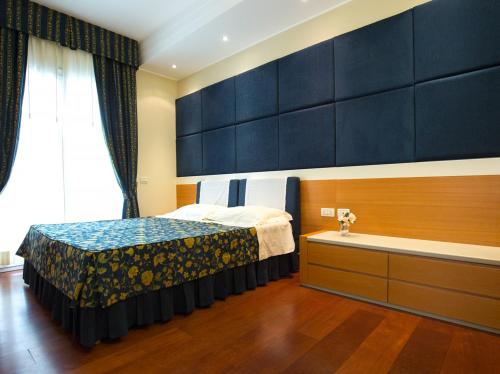 a bedroom with a bed and a large window at Aparthotel England in Riccione