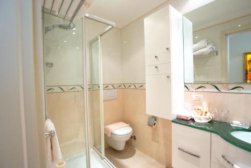 ein Bad mit einer Dusche, einem WC und einem Waschbecken in der Unterkunft Aparthotel England in Riccione