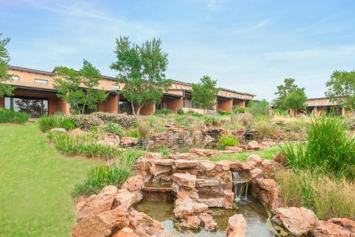 a garden with a pond in front of a building at Riverstone Lodge in Muldersdrift
