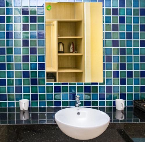 La salle de bains est pourvue d'un lavabo et d'un miroir. dans l'établissement Flora Hotel - Phan Rí Cửa, à Ấp Lâm Lộc