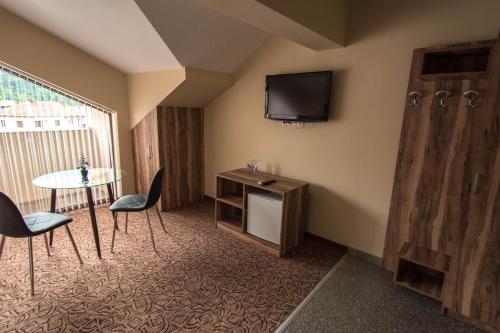 a room with a table and a tv on the wall at Etobicoke -Стаи за гости in Etropole