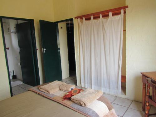 a room with a bed with a pair of scissors on it at Pumula Guest Farm in Fouriesburg