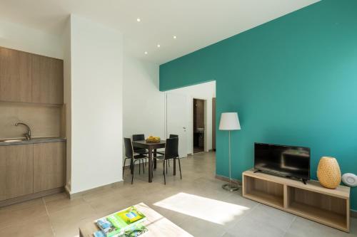 a kitchen and living room with a blue wall at Local Hostel & Suites in Corfu Town