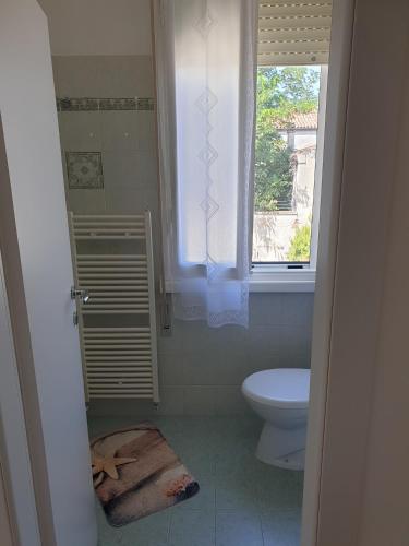 a bathroom with a toilet and a window at I TREPPONTI in Comacchio