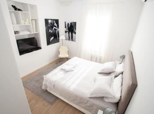 une chambre blanche avec un lit et une télévision dans l'établissement Magnifique 2 pieces frontiere Monaco, à Beausoleil