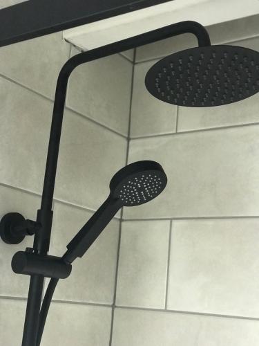 a shower with a shower head in a bathroom at Rylands Farm Guest House in Wilmslow
