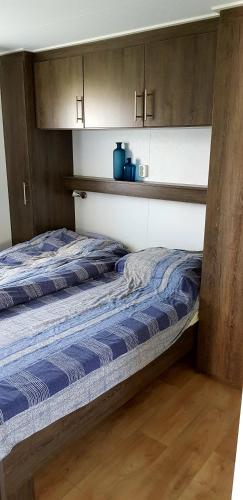 a bedroom with two beds and wooden cabinets at De Zeeuwse Lûûkjes 1 in Serooskerke