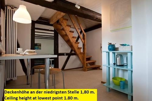 a living room with a table and a staircase at 1463 Apartmenthaus in Karlsruhe
