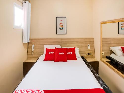 ein Schlafzimmer mit einem großen weißen Bett mit roten Kissen in der Unterkunft OYO Hotel Itarantim, São Paulo in São Paulo