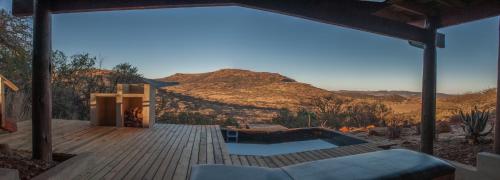 a deck with a pool and a view of the desert at Three Tree Hill Lodge in Bergville