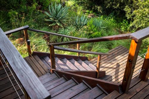 a wooden stairway with a wooden bench on it at Three Tree Hill Lodge in Bergville