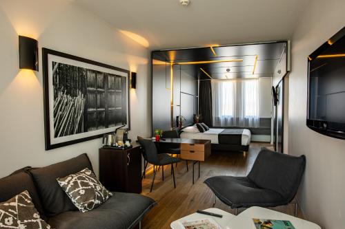 ヴィルフランシュ・シュル・ソーヌにあるMercure Villefranche en Beaujolaisのベッド1台付きの部屋、ソファ付きのリビングルームが備わります。