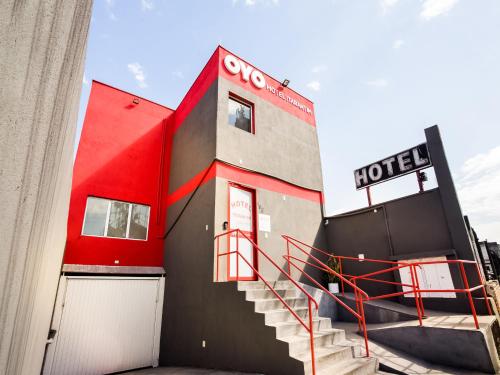 een hotel met een rood gebouw met een trap bij OYO Hotel Itarantim, São Paulo in Sao Paulo