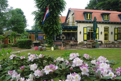 a house with a bunch of flowers in front of it at Hotel Vierhouten in Vierhouten