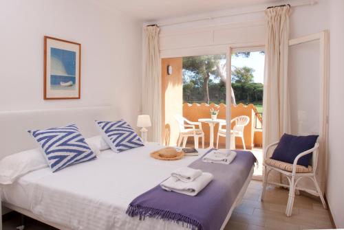 1 dormitorio con 1 cama con almohadas azules y blancas en Villa Familiar by La Costa Resort, en Pals