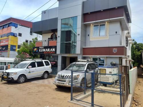 two cars parked in a parking lot in front of a building at SREE Kumaran Residence in Rāmeswaram